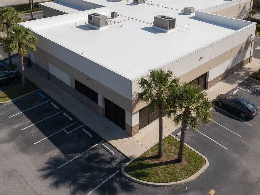 White TPO flat roof with rooftop air conditioning units on a one story commercial building