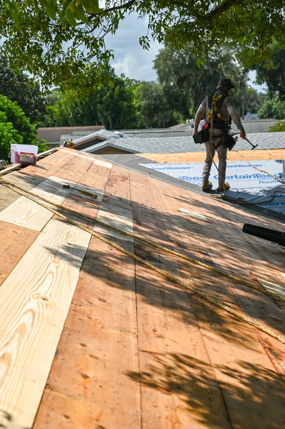 Gold Key roofer walking across new board decking during a roof replacement