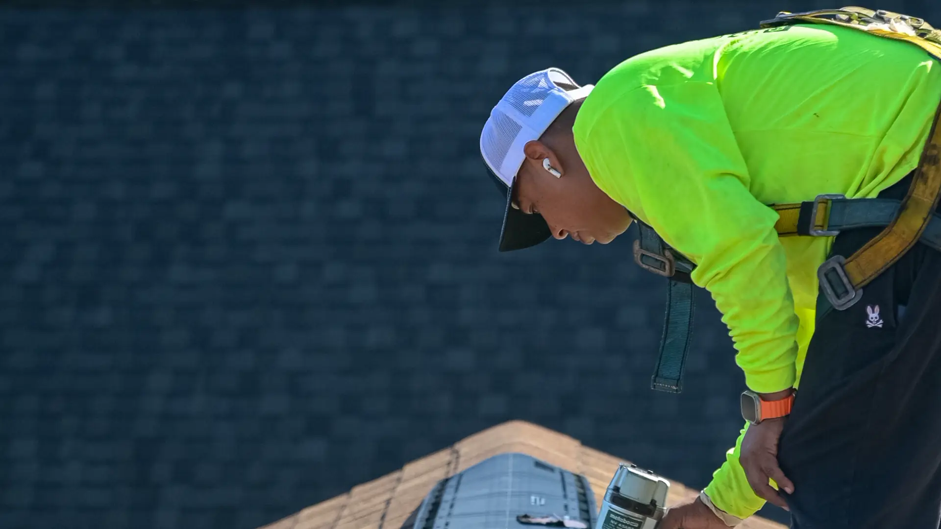 Gold Key roofer nailing down a ridge vent along the peak of a shingle roof