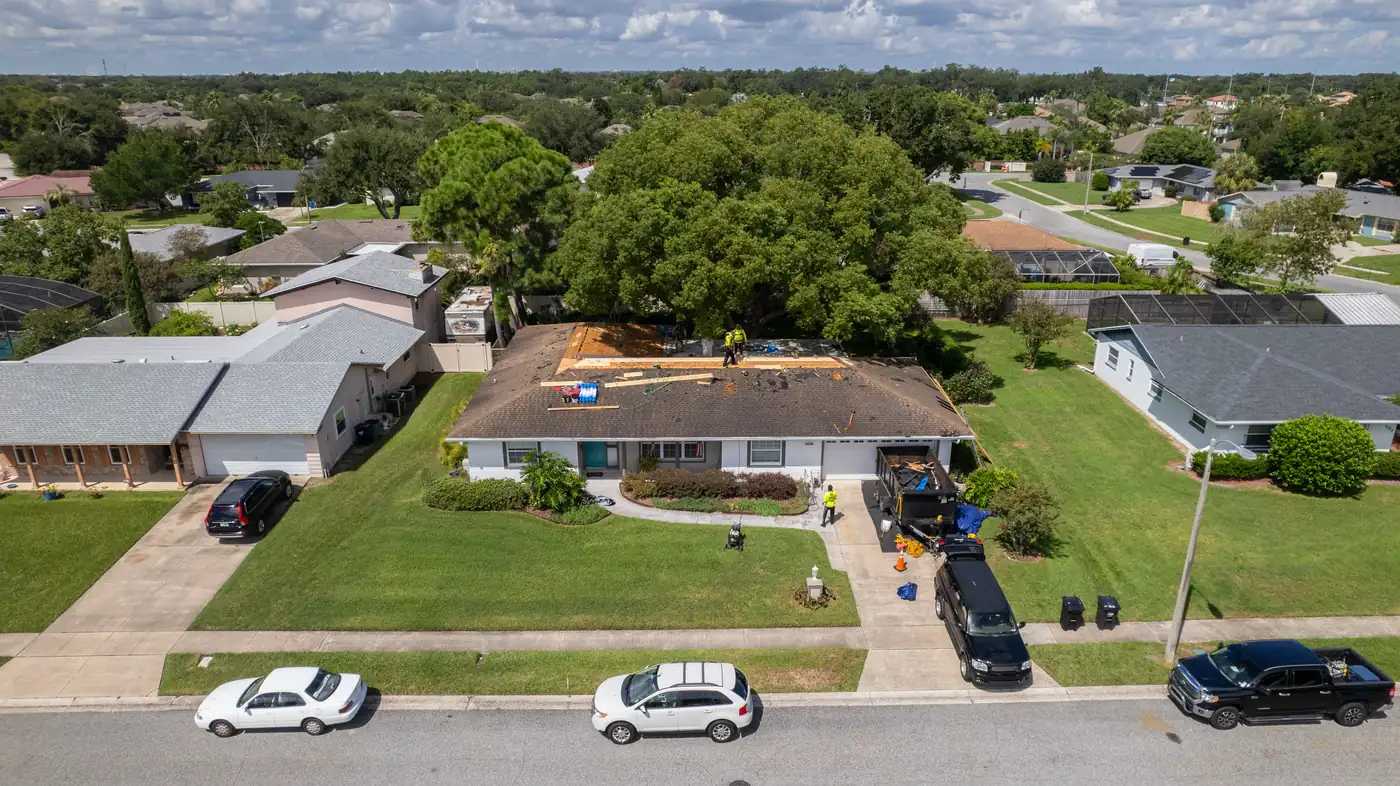 Aerial view of a neighborhood street with a Gold Key crew reroofing one home
