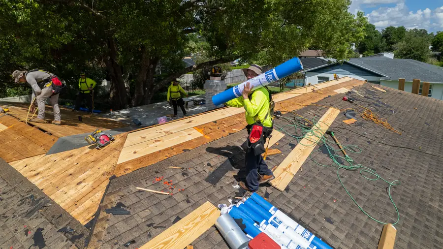 Gold Key crew replacing roof decking after tearing off an old shingle roof, seen from above