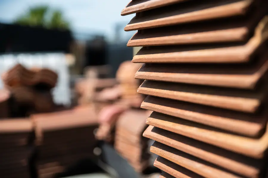 Stacked clay barrel roof tiles on a job site