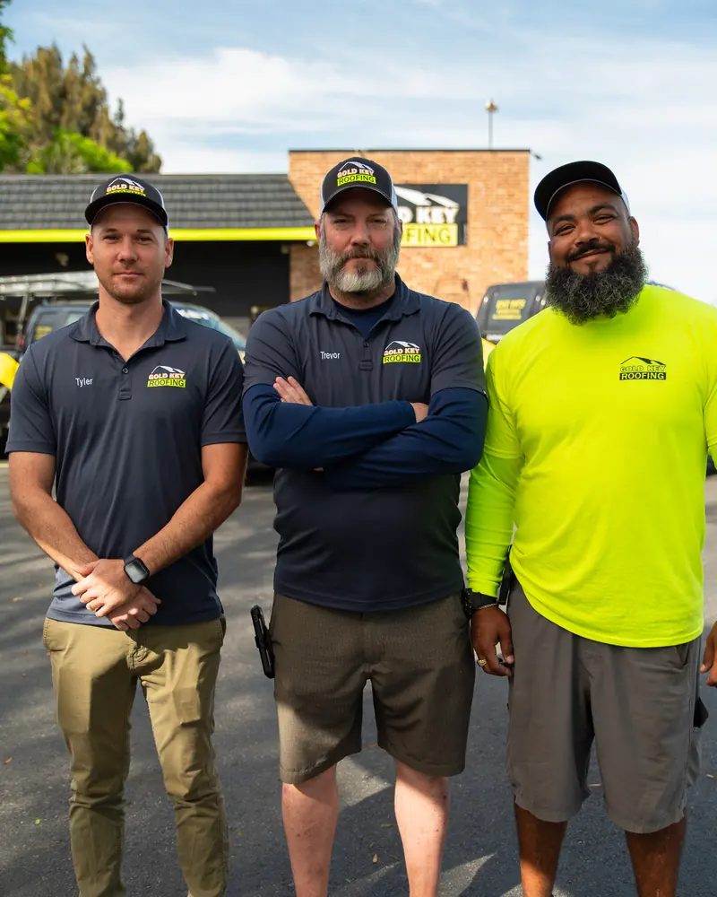 Three Gold Key Roofing team members standing together outside the office