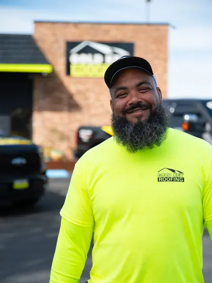 Gold Key Roofing crew member in a bright yellow shirt
