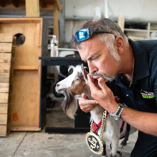 A team member leaning in nose to nose with Roofus