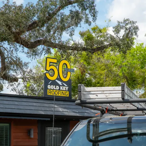 A 50 sign on top of a Gold Key Roofing truck